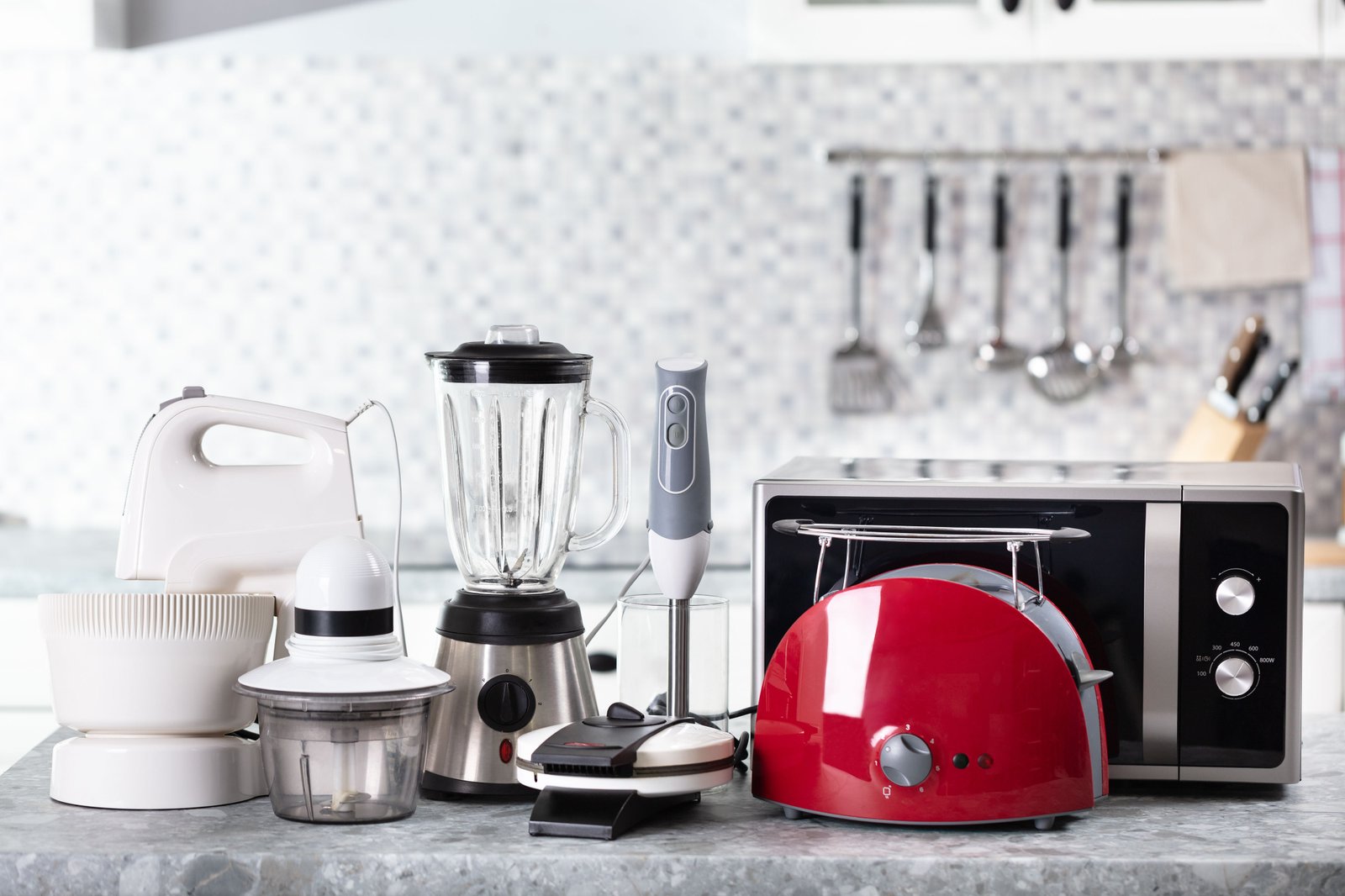 Small household appliances on a kitchen counter including a toaster, blender, and coffee maker being repaired
